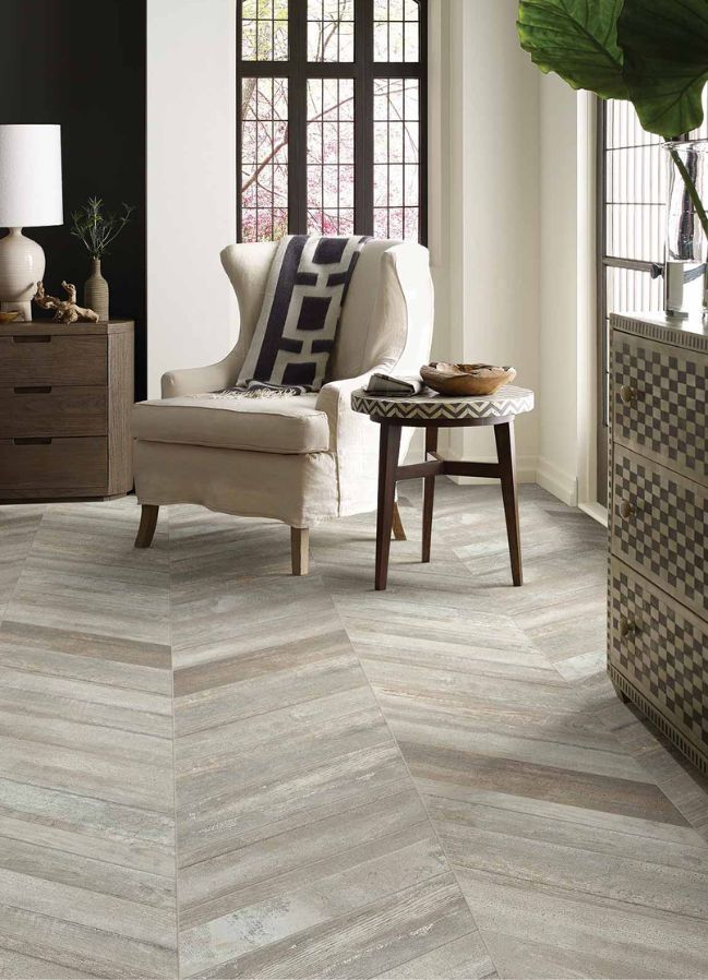 wood look tile flooring in a elegant living room with large windows and upholstered chair